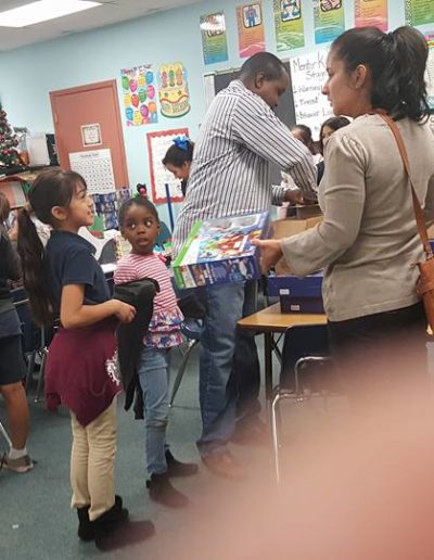 Kids receiving their toys from the adults