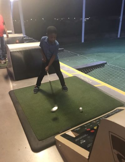 A boy aiming his golf club for the ball