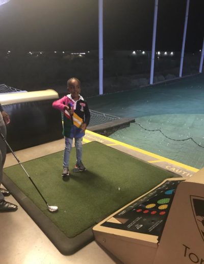 A child learning how to play golf