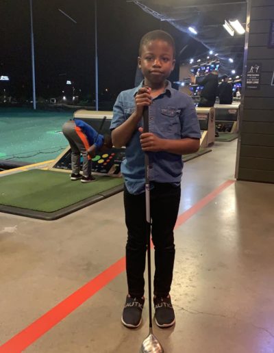 A boy holding a long golf club