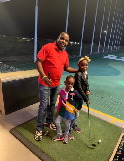 A man playing golf with two girls