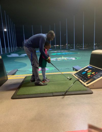 A man and a little girl playing golf