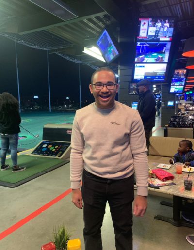 A happy man wearing glasses and a sweater