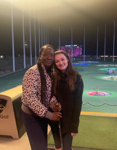 Two happy women standing near the golfing platform